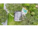 Aerial view of a private backyard with a sparkling pool surrounded by lush landscaping and mature trees at 510 Se 19Th St, Ocala, FL 34471