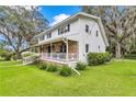 Charming two-story home with a brick facade, inviting front porch, and well-maintained lawn surrounded by mature trees at 510 Se 19Th St, Ocala, FL 34471