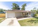 Single-story home featuring an attached garage, classic shutters, adjacent to a long, paved driveway at 5596 Nw 57Th St, Ocala, FL 34482