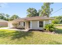 Single-story home featuring classic shutters, a well-manicured lawn and attractive landscaping at 5596 Nw 57Th St, Ocala, FL 34482