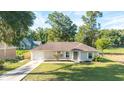 Charming single-story home features a well-manicured lawn, classic shutters, and an attached one-car garage at 5596 Nw 57Th St, Ocala, FL 34482