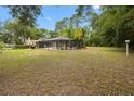 Expansive backyard with a view of the pool and mature trees offering a private oasis at 581 Ne 44Th Ave, Ocala, FL 34470