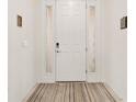 Bright foyer featuring a white door with sidelights and a neutral-toned striped rug at 6175 Sw 88Th Loop, Ocala, FL 34476