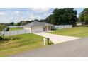 Lovely single story home with a well-manicured lawn, long driveway, white fence and an attached two-car garage at 6250 Se 88Th St, Ocala, FL 34472