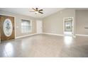 Spacious open-concept living room featuring tile flooring, high ceilings, and ample natural light from large windows at 8937 Se Highway 42, Summerfield, FL 34491