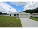 Charming single-story home with a well-manicured lawn and attached two car garage at 9 Hemlock Terrace Ln, Ocala, FL 34472