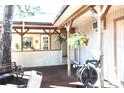 View of the wooden deck with hanging plants, a bench, and an outdoor faucet with hose reel at 25600 Se 152Nd Pl, Umatilla, FL 32784