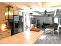 Open-concept kitchen and living room featuring modern lighting, stainless steel appliances, and neutral colored walls at 25600 Se 152Nd Pl, Umatilla, FL 32784