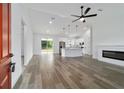 Open-concept living room featuring wood floors, a fireplace, and modern lighting at 5 Willow Trl, Ocala, FL 34472