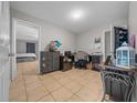 Bedroom showcasing tiled flooring and a calming blue accent wall and access to the main bedroom at 5018 Se 106Th Pl, Belleview, FL 34420