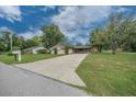 Inviting single-story home with a long driveway and a well-maintained lawn with mature shade tree at 5018 Se 106Th Pl, Belleview, FL 34420