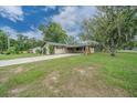 Cozy home with a long driveway leading to a carport, complemented by a lush lawn at 5018 Se 106Th Pl, Belleview, FL 34420