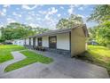 Side view of a charming home with a stone base and updated walkway at 6021 Nw 54Th Ter, Ocala, FL 34482