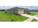 View of the house with green lawn and driveway, highlighting a well-kept exterior at 7828 Sw 74Th Loop, Ocala, FL 34481