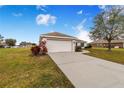 House exterior showcasing a garage and driveway, surrounded by a grassy yard at 1518 Blue Sky Blvd, Haines City, FL 33844