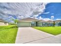 Two-story house with green exterior, landscaping, and a two-car garage at 4024 Tullamore Ln, Auburndale, FL 33823