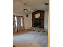 Inviting living room features a stone fireplace and a ceiling fan at 4450 Old Berkley Rd, Auburndale, FL 33823