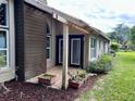 Cozy back porch featuring brick flooring, potted plants, and access to the house via french doors at 416 Sandestin Dr, Winter Haven, FL 33884