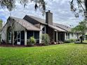 View of the house from the backyard, showcasing the screened porch and chimney at 416 Sandestin Dr, Winter Haven, FL 33884