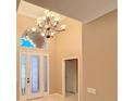 Spacious foyer featuring high ceilings, chandelier, and transom window above the front door at 4577 Back Nine Dr, Winter Haven, FL 33884
