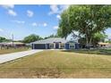 Charming blue home with a well-manicured front lawn and beautiful curb appeal at 1396 Lucerne Loop Ne Rd, Winter Haven, FL 33881