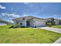 Well maintained single story home featuring an attached two car garage and lush green lawn at 2123 Cartgate Lane, Winter Haven, FL 33884