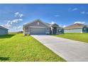 New home exterior with driveway and green lawn at 4081 Tullamore Ln, Auburndale, FL 33823