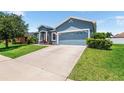 A long driveway leading to an attached 2-car garage on a home with a well-manicured lawn at 192 Viola Dr, Auburndale, FL 33823