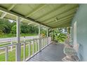 Relaxing front porch with white railing overlooking a tree-lined street at 954 Reynolds Rd, Lakeland, FL 33801
