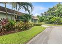 Well-maintained front yard with lush landscaping, mature palms, and verdant green lawn at 2200 Starboard, Winter Haven, FL 33881