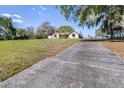 View of the home and long driveway leading to a beautiful, well-maintained lawn at 9650 W Lake Marion Rd, Haines City, FL 33844