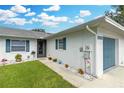 House exterior showcasing a walkway to the entrance and a blue garage door at 1521 Oakview Se Cir, Winter Haven, FL 33880