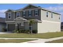 Two-story house with gray siding, stone accents, and palm trees at 605 Sarner Pass Way, Winter Haven, FL 33881