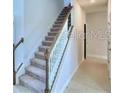 A staircase with carpeted steps and a white railing, lit by natural light at 1476 Leamington Lane, Winter Haven, FL 33884