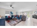 Bright living room with a ceiling fan, a comfortable blue couch, and access to the outdoor space at 208 Summerlin Ln, Haines City, FL 33844