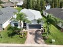 One-story house with a gray roof, palm trees, and a brick driveway at 4104 Martindale Loop, Winter Haven, FL 33884