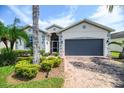 Charming single-story home featuring a two-car garage, beautiful landscaping and a brick paved driveway at 4104 Martindale Loop, Winter Haven, FL 33884