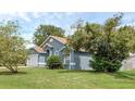 Blue house with green landscaping and large trees at 752 Hunt Dr, Lake Wales, FL 33853