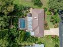 Aerial shot showcases a sparkling pool, patio and metal roof of the home at 3808 Gaines Dr, Winter Haven, FL 33884