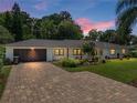 Charming home with brick paver driveway, dark garage door and beautifully landscaped yard at 3808 Gaines Dr, Winter Haven, FL 33884