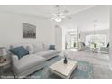 Bright living room featuring neutral tones, ceiling fan, and large windows for ample natural light. 'THIS IMAGE IS VIRTUALLY STAGED' at 142 Morning Glory Cir, Winter Haven, FL 33884