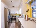 Bright kitchen featuring stainless steel appliances and white cabinets at 623 W Shady Ln, Lakeland, FL 33803