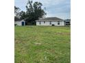 Large backyard with a storage shed, green grass, and rear view of the home at 720 S Morrison Ave, Fort Meade, FL 33841