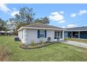 View of the front yard of a single-story home with blue shutters and green lawn at 720 S Morrison Ave, Fort Meade, FL 33841