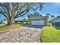 A two-car garage with a brick paved driveway and mature landscaping at 579 Saint Andrews Rd, Winter Haven, FL 33884