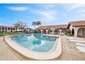 Community pool area with comfortable lounge chairs and tables underneath shade umbrellas at 6001 Country Club Dr, Lake Wales, FL 33898