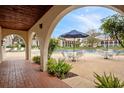 View from covered patio of pool area with tables and chairs surrounded by lush landscaping at 6001 Country Club Dr, Lake Wales, FL 33898