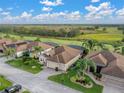 Beautiful aerial view of a home with a screened-in lanai, lush landscaping, and a brick driveway in a serene neighborhood at 4193 Stone Creek Loop, Lake Wales, FL 33859