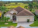 Beautiful single-story home showcasing a manicured lawn and three-car garage and front entryway at 4193 Stone Creek Loop, Lake Wales, FL 33859