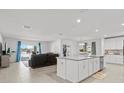Open-concept living room and kitchen with a large island and stainless steel appliances at 912 Scrub Oak Hammock Rd, Davenport, FL 33837
